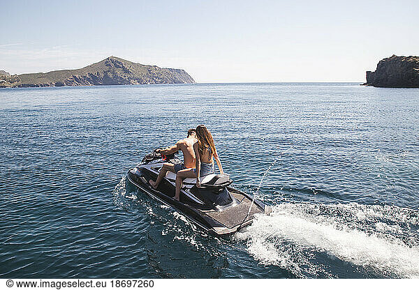 Couple sitting on jetski in water