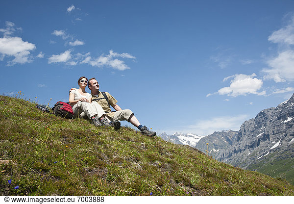 Couple Sitting on Mountain Side  Bernese Oberland  Switzerland