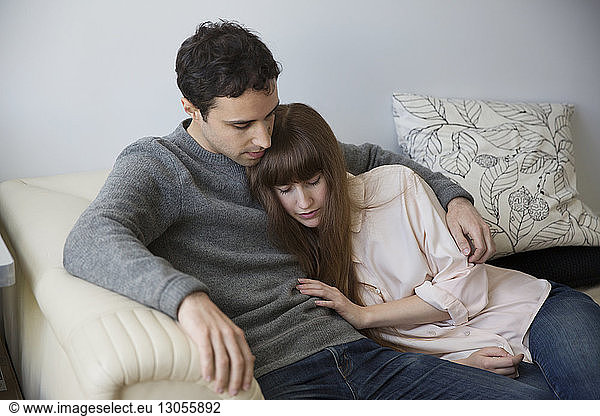 Couple sitting on sofa at home