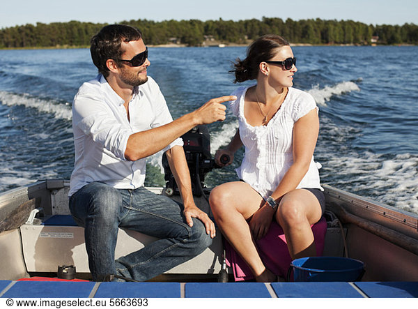 Couple sitting together on motorboat