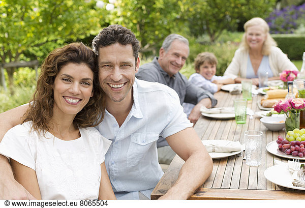 Couple smiling at table outdoors