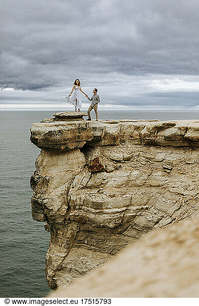 Couple stand on edge of dramatic cliff Pictured Rocks Lakeshore