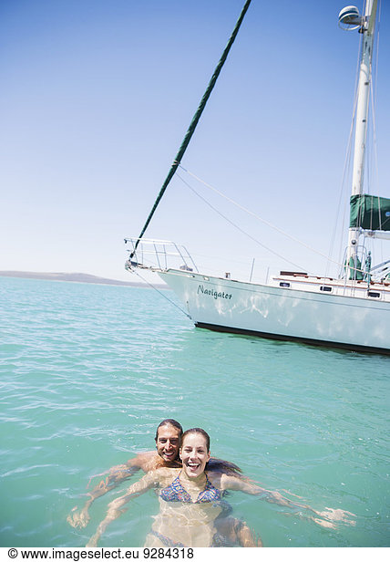 Couple swimming in water near boat