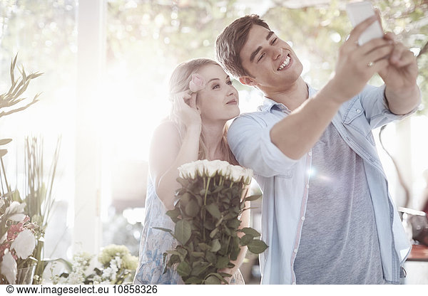 Couple taking selfie at flower shop