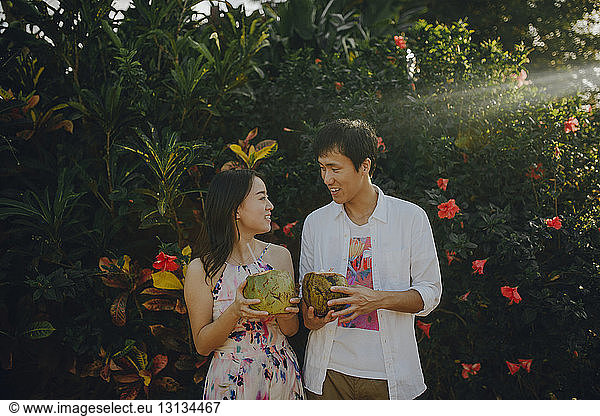 Couple talking while drinking coconut water at park
