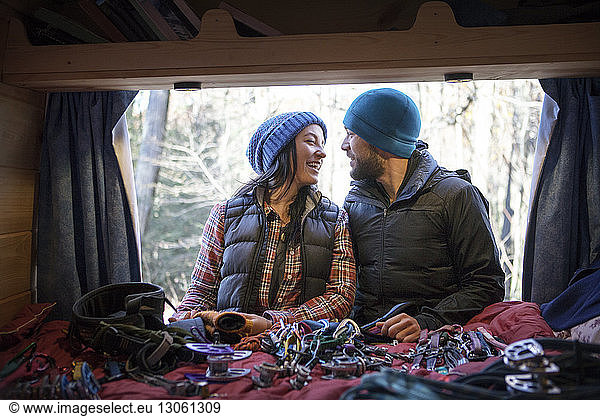 Couple talking while standing by camper van