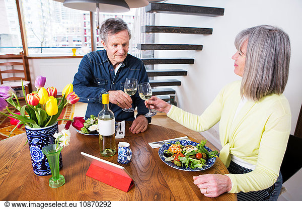 Couple toasting at dining table