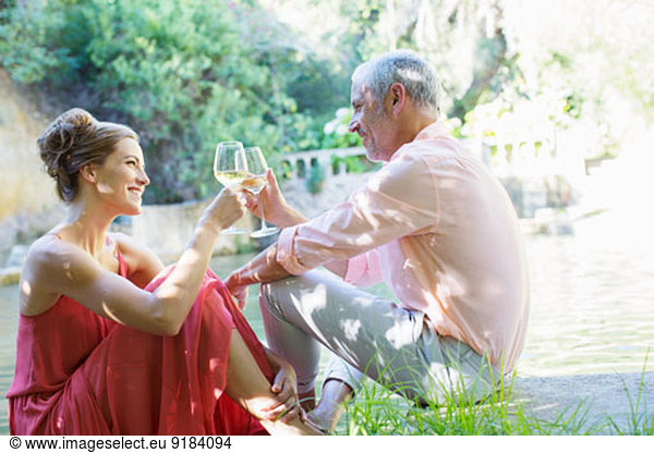 Couple toasting each other outdoors
