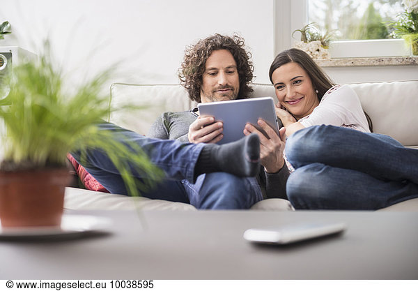 Couple using digital tablet at home  Munich  Bavaria  Germany