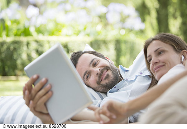 Couple using digital tablet outdoors