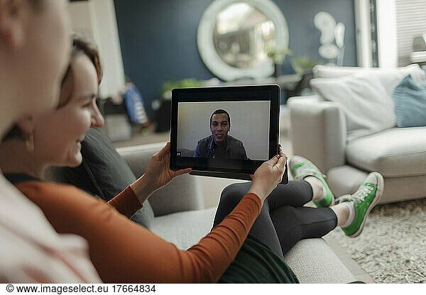Couple video chatting with friend on digital tablet
