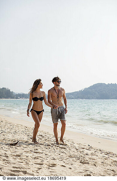 Couple walking on sand at beach