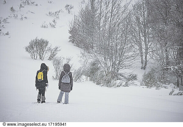 couple walking through snowy field