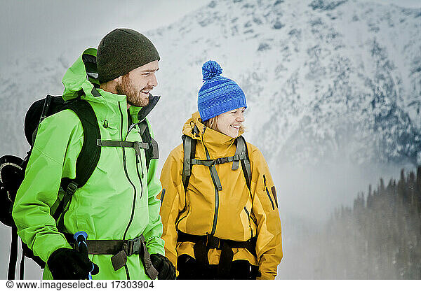 Couple wearing winter jackets in outdoor mountain setting.