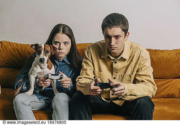 Couple with dog playing video game in living room