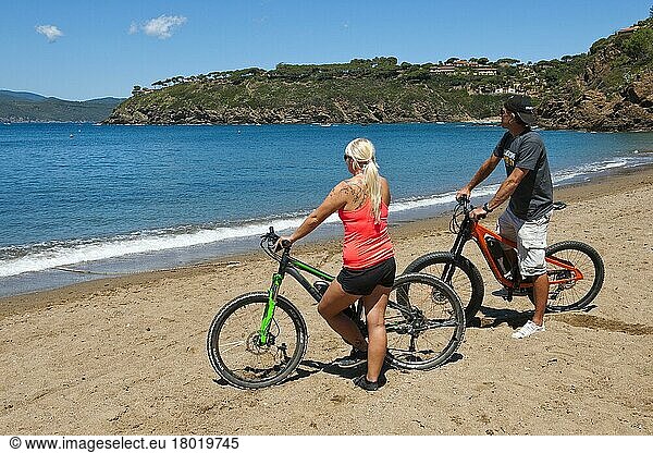 Couple with electric bikes on the beach  Europe  Morcone  Elba  Tuscany  Italy  Europe