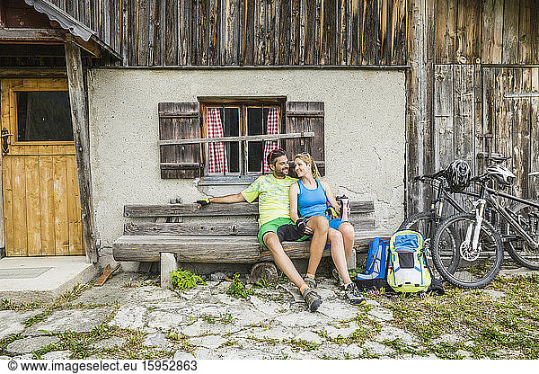 Couple with mountain bikes having a break at a mountain hut  Achenkirch  Austria