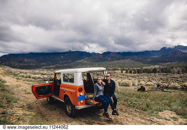 Couple with vehicle on scrubland by mountains  Kennedy Meadows  California  USA