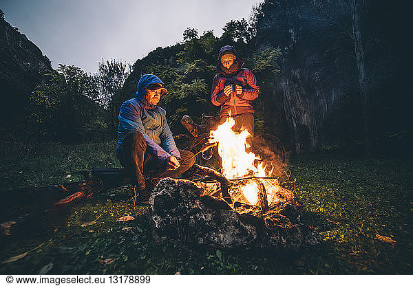 Couple with with bikes at camp fire
