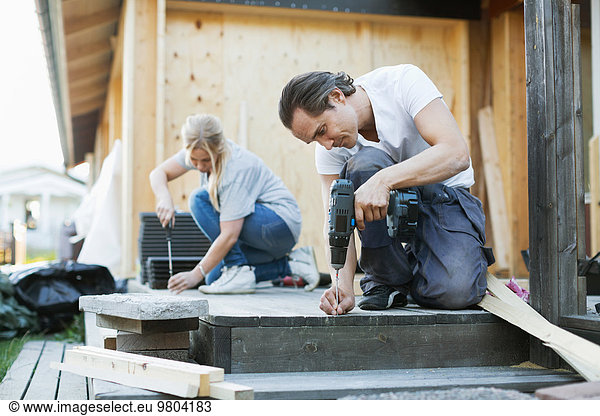 Couple working outside house during home improvement