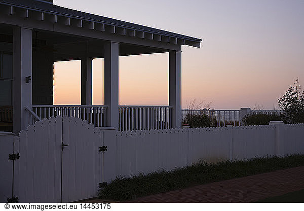 Covered Porch And Fence At Sunset