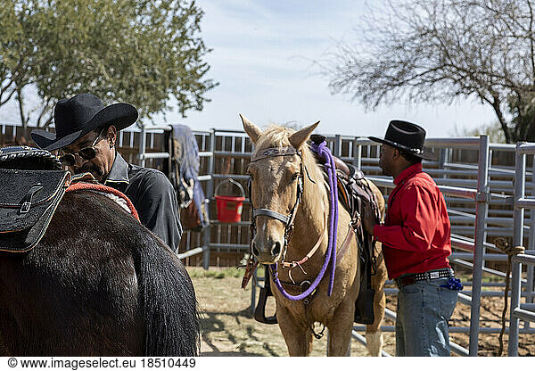 Cowboys prepare their horses backstage at the Arizona black rodeo