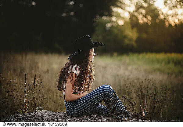 Cowgirl in field looking over pasture