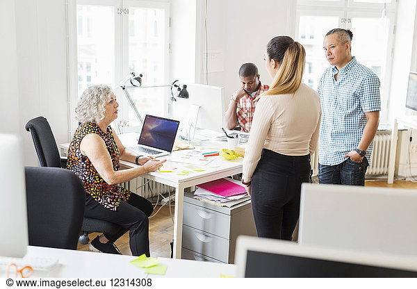Coworkers discussing project in office