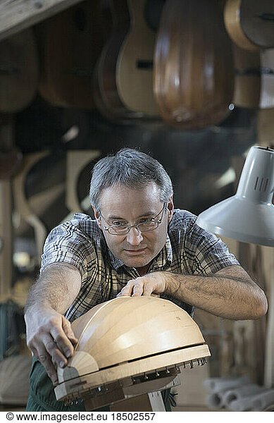 Craftsman manufacturing lute at workshop
