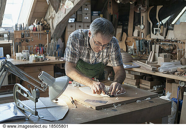 Craftsman manufacturing lute at workshop