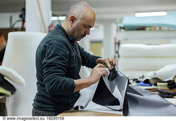 Craftsman working with fabric in workshop