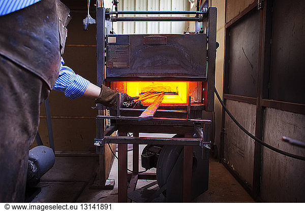 Craftsperson melting metal at factory