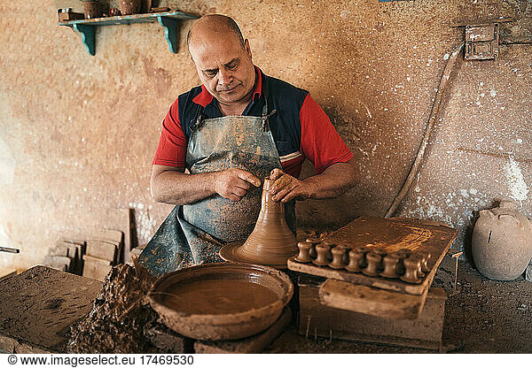 Craftsperson shaping earthenware at pottery