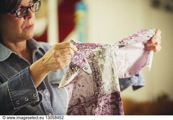Craftswoman examining prints on fabric at workshop