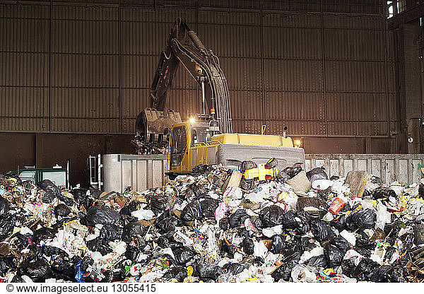 Crane collecting garbage in recycling plant
