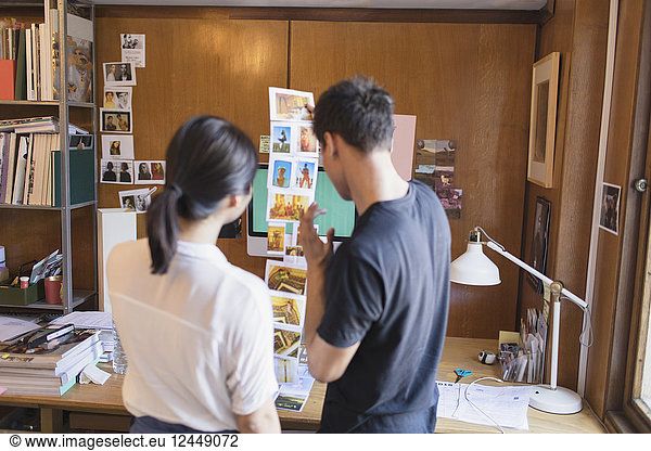 Creative designers reviewing photograph proofs in office