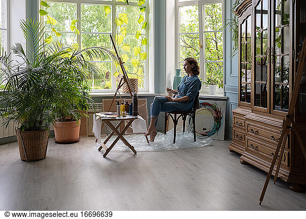 Creative woman admiring artwork in studio