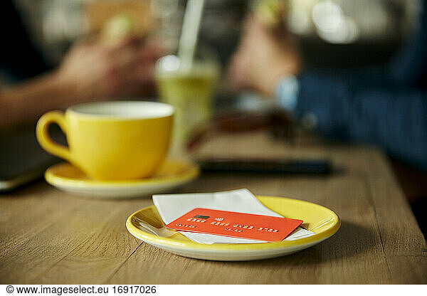 Credit card and bill on cafe table