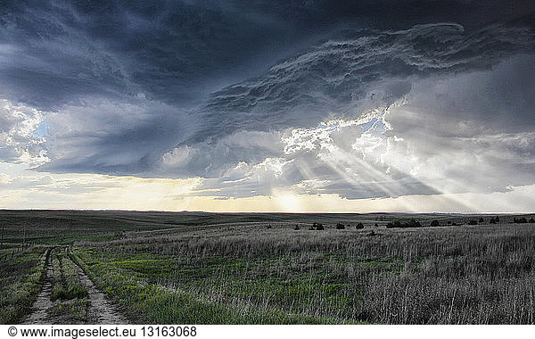 Crepuscular rays forming under shelf cloud  rotating mesocyclone in background  Sidney  Nebraska  USA