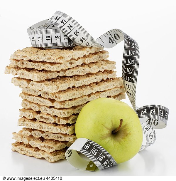 Crispbread  in a pile  and apple with tape measure