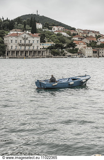 Croatia  Dubrovnik  view to the city with man in boat in the foreground