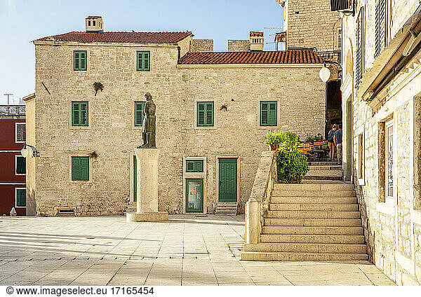 Croatia  Sibenik-Knin County  Sibenik  Steps leading to building standing on Trg Republike Hrvatske square with statue in background