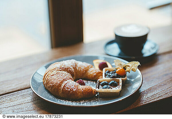 Croissant and coffee on table