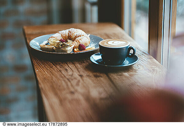 Croissant and coffee on table at cafe