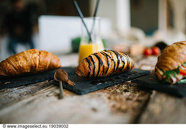 Croissant for breakfast on rustic wooden table.