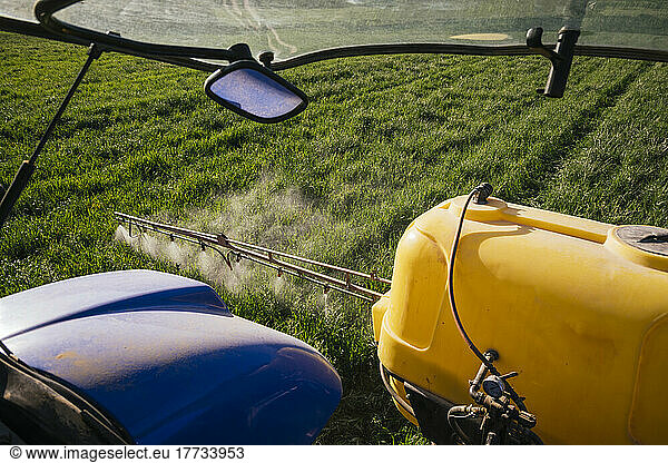 Crop sprayer spraying fertilizer on field