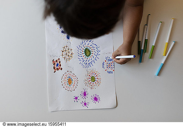 Crop view of little boy drawing flowers