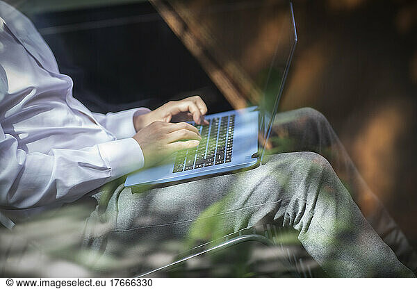 Cropped businessman working at laptop