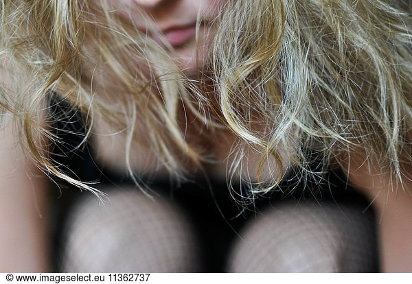 Cropped close up of woman hugging knees