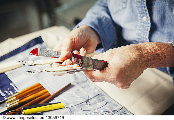 Cropped hands of craftswoman holding hand tools at workshop